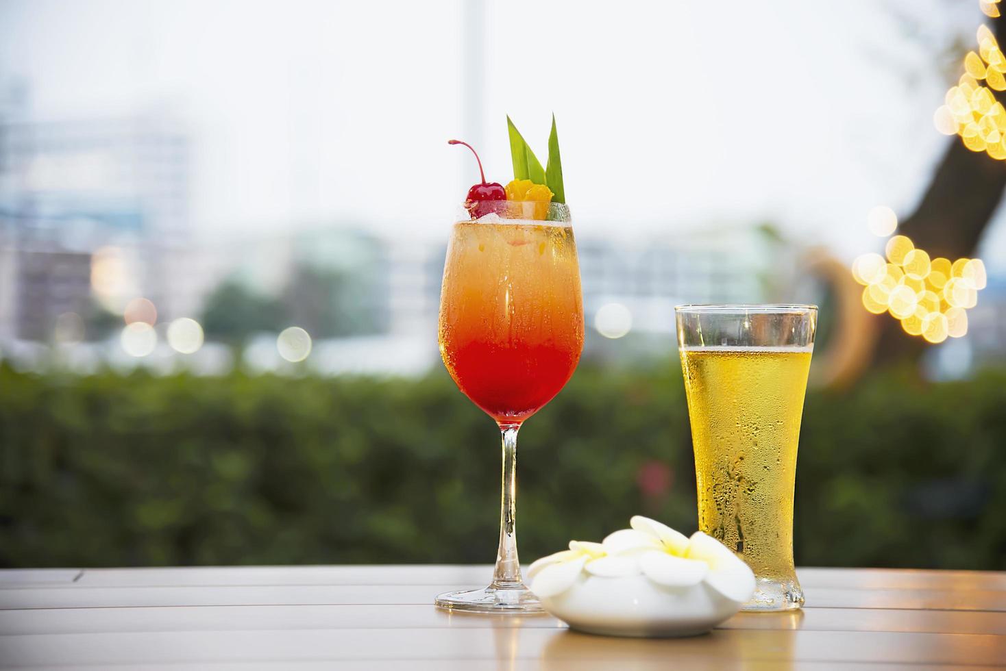 glas kall öl och mai tai eller mai thai över hela världen gynnar cocktail i skymning - söt alkoholdryck slappna av semester bakgrundskoncept foto