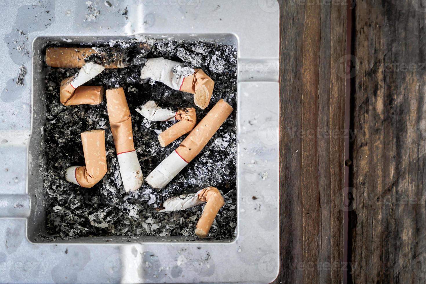 rökta cigarettfimpar i askkopp foto