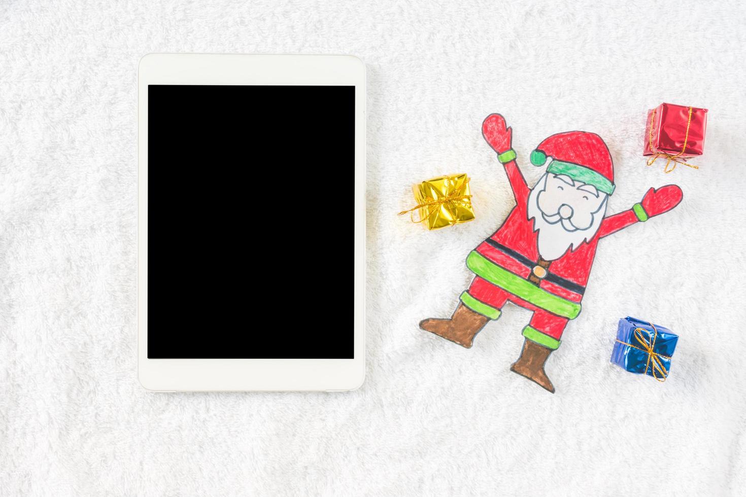 ovanifrån av jultomten med gåvor och tablett på vit bakgrund. jul koncept foto