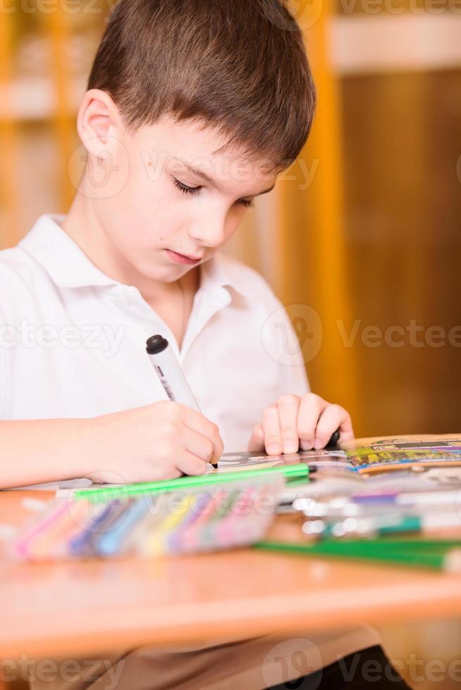 koncentrerad pojke målarbok porträtt foto