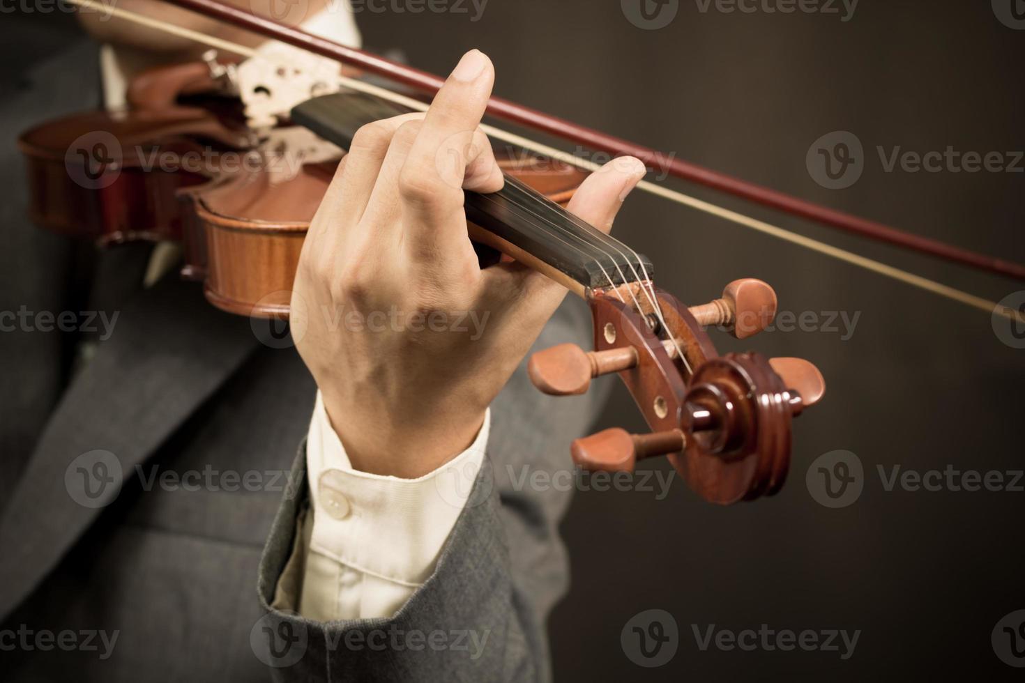 asiatisk musiker spelar fiol på mörk bakgrund foto