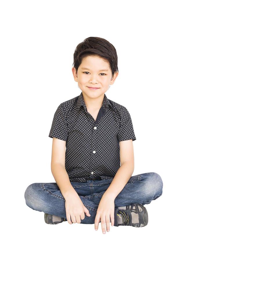 porträtt av leende sittande pojke isolerad över vit bakgrund foto