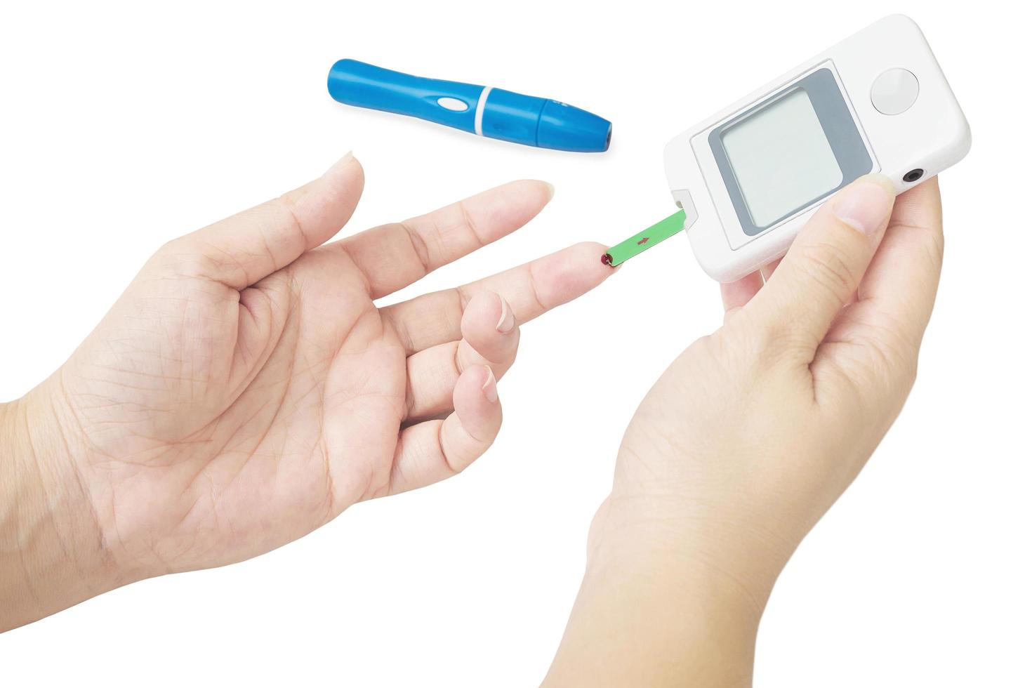kvinnan kontrollerar diabetes med hjälp av blodkontrollkit isolerade över vita foto
