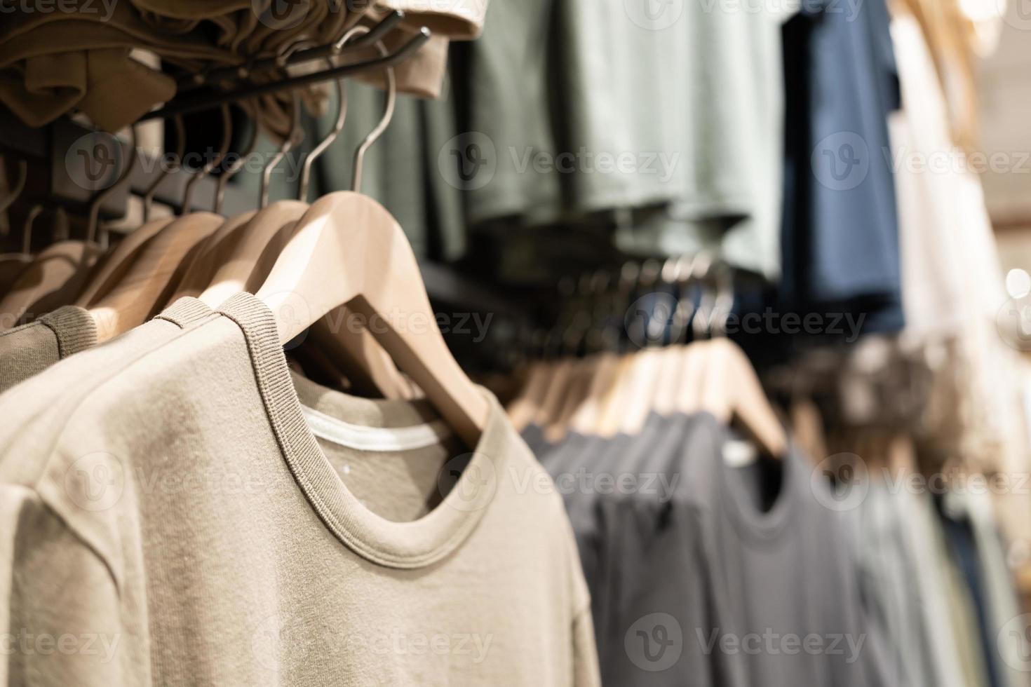 selektivt fokus, mode, klädkoncept, kläder eller byxor många färger hänger på en hylla i en märkesbutik. mycket pastellfärgat foto