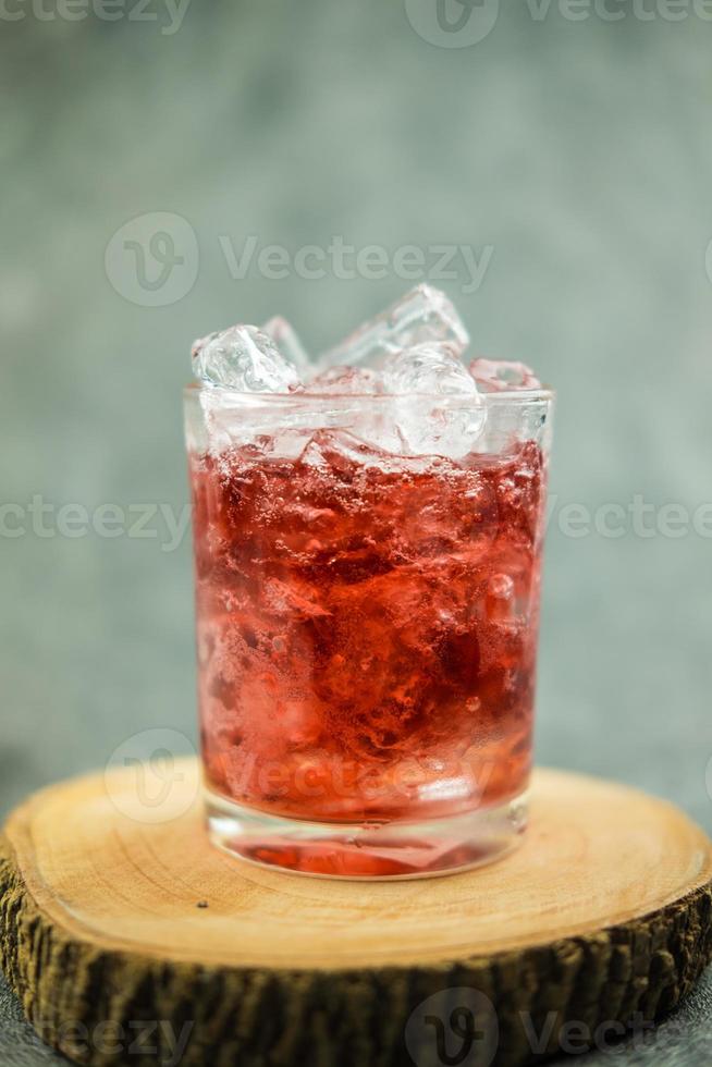 mousserande röd vatten soda med isbitar. sommar isdryck foto