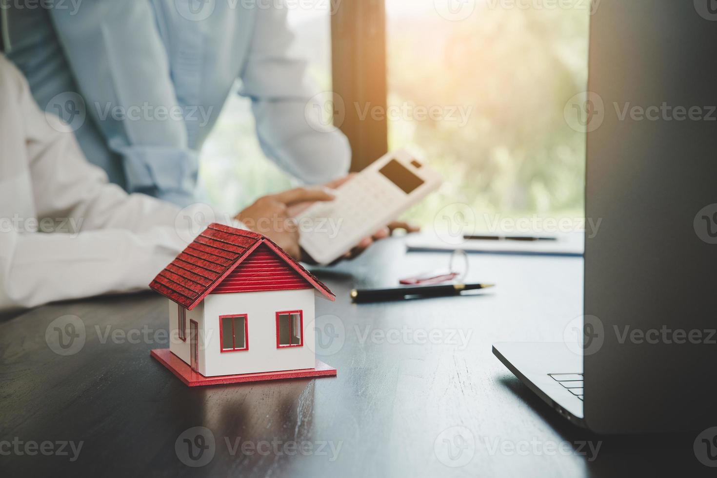 fastighetsmäklare presenterar och rådgör med kund till beslutsfattande teckna försäkringsformulär avtal, hemmodell, gällande bolåneerbjudande för och villaförsäkring. foto