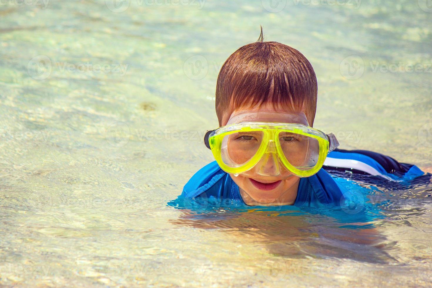 pojke med vått hår bär en mask till sjöss efter dykning foto