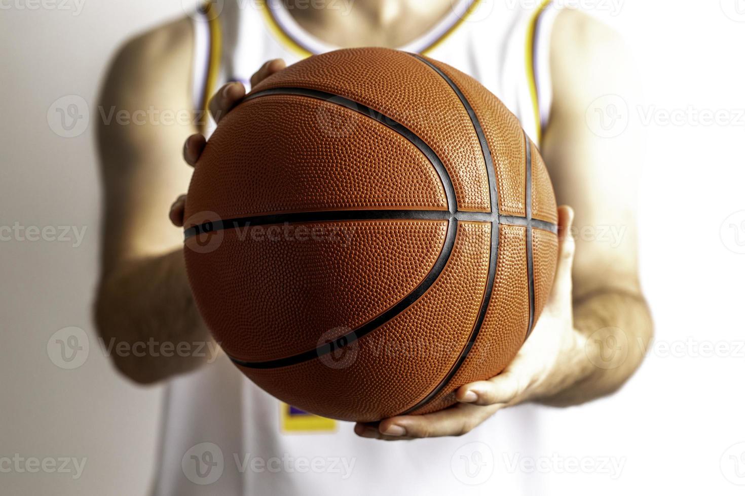 håller en basketboll foto