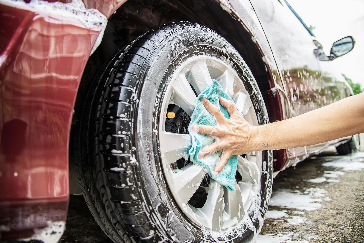 man tvättar bil med schampo - vardagsliv bilvårdskoncept foto
