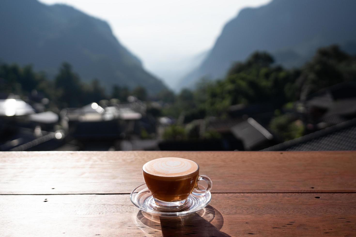 utsikt över varm mjölk te lattekonst på träbord med relaxlandskap i byn pha hee, chiang rai, thailand foto