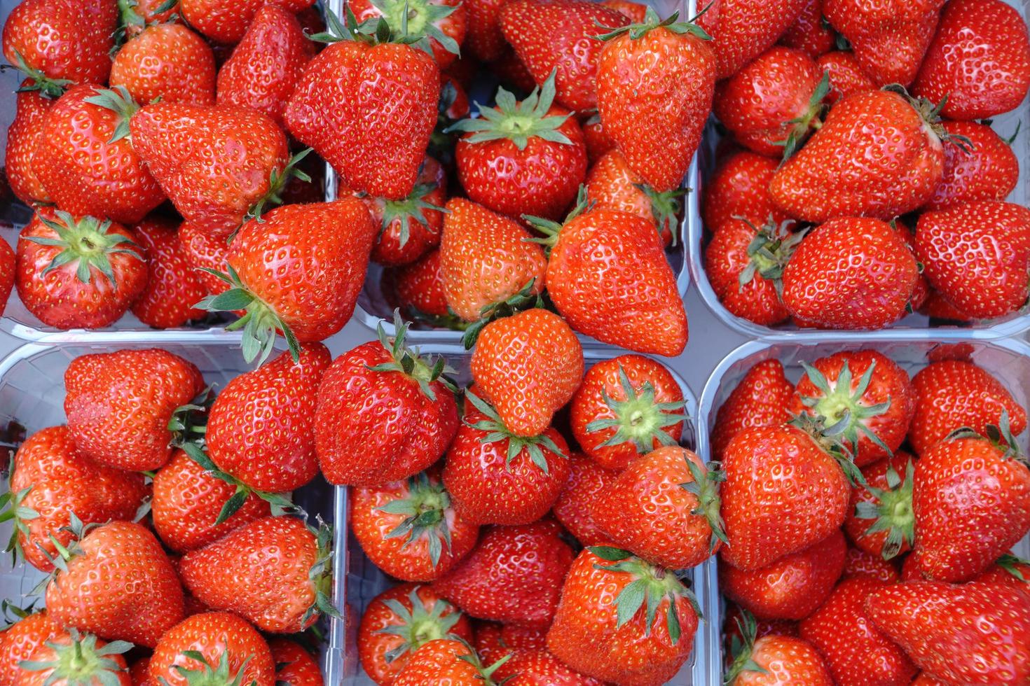 korgar med färska läckra jordgubbar i butik, närbild. foto