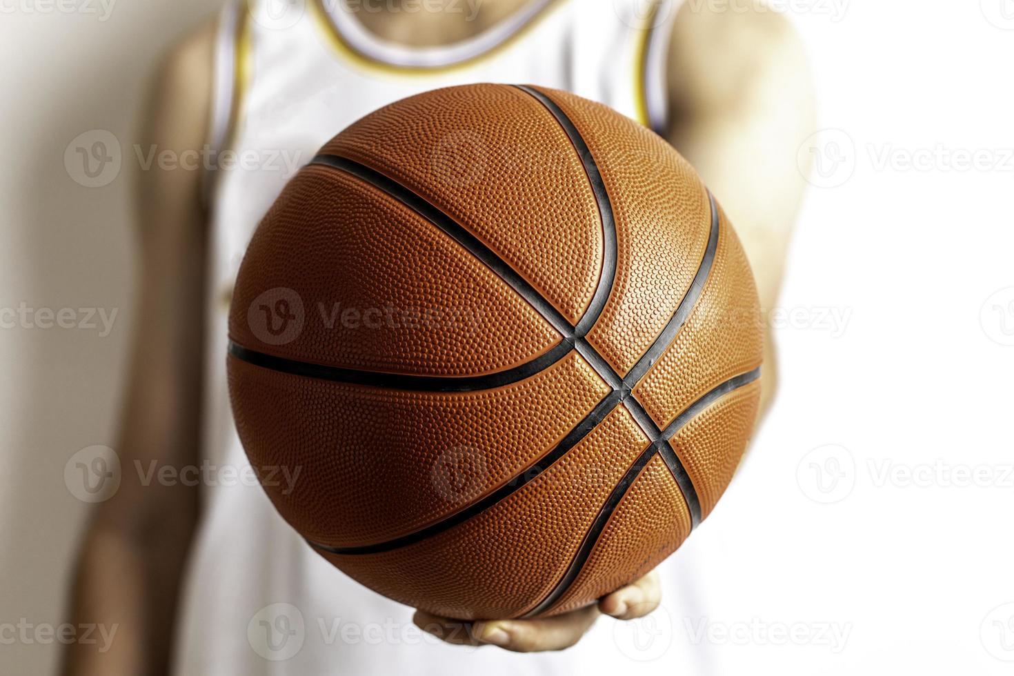 håller en basketboll foto