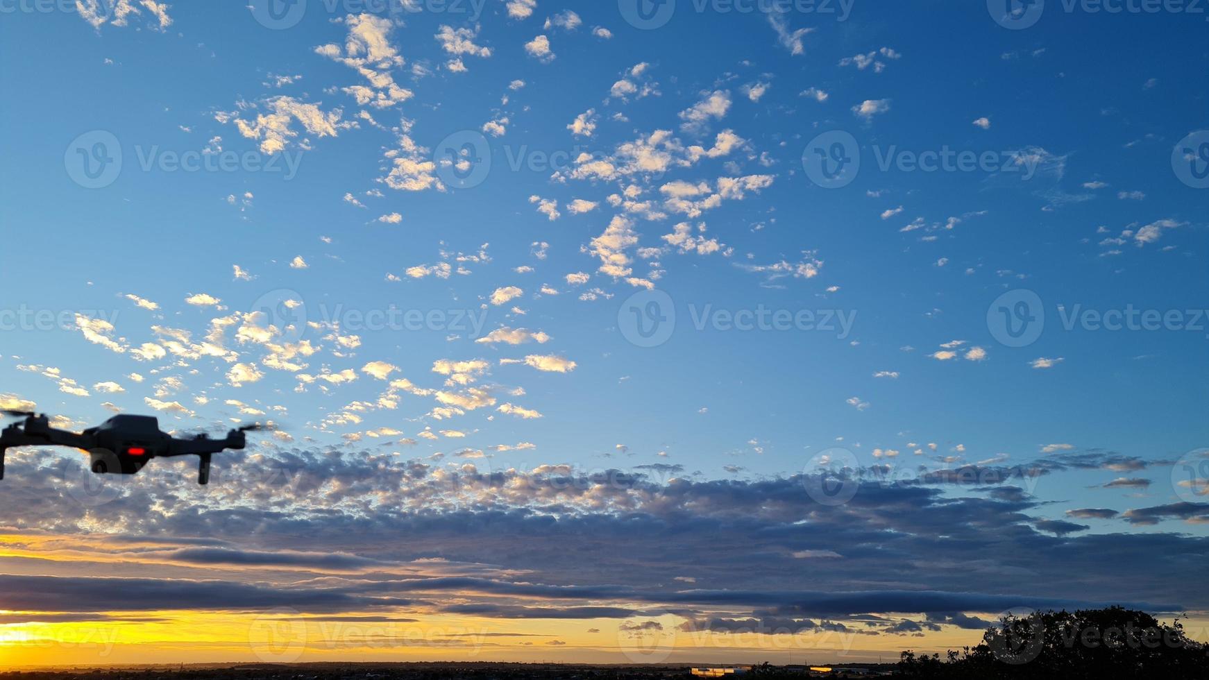 en drönare flyger vid vacker och färgglad solnedgång med moln på himlen foto