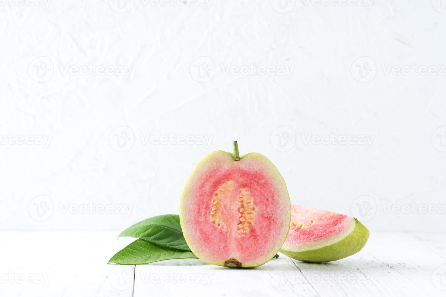 närbild av vacker röd guava med färska gröna blad. foto