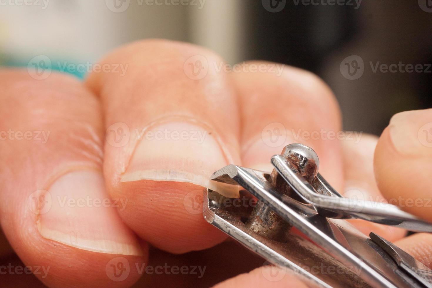 man klipper naglarna med ett par nageltrimmers foto