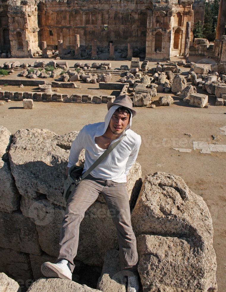 ung man som bär en hatt på en gammal romersk ruin i baalbek, Libanon foto