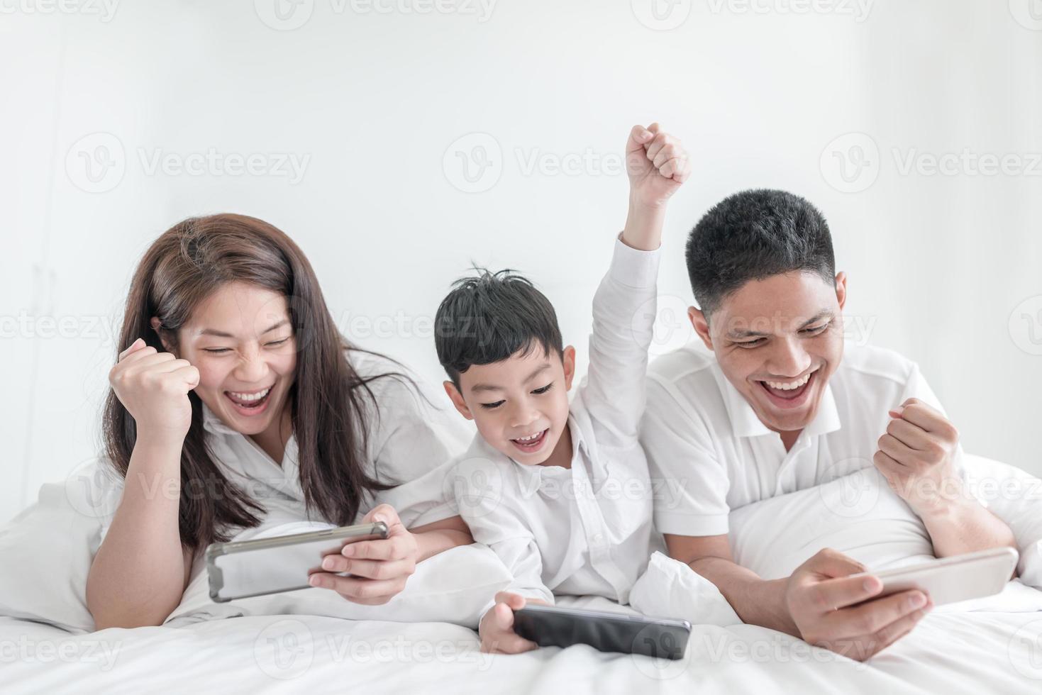 porträtt lycklig familj mamma pappa och son ler i sovrummet. titta på varandra. foto