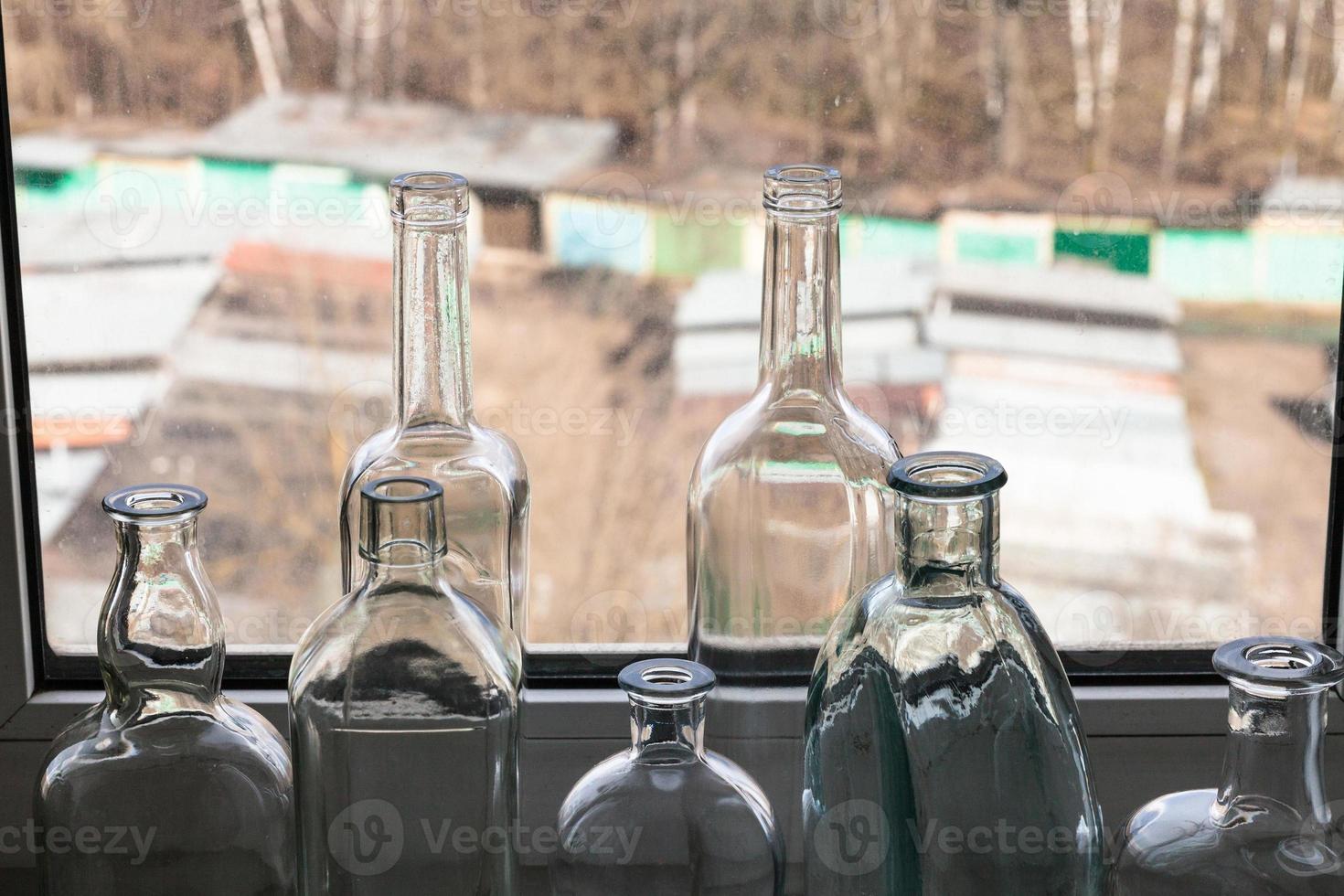 tomma flaskor på fönsterbrädan och utsikt över stadsgården foto