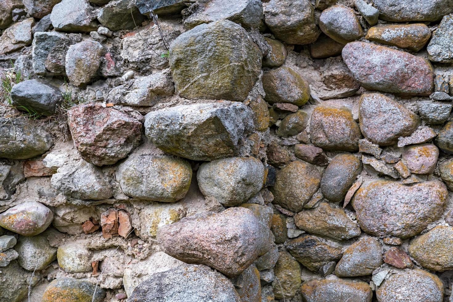 ytan av en gammal mur av enorma stenar av en förstörd byggnad foto