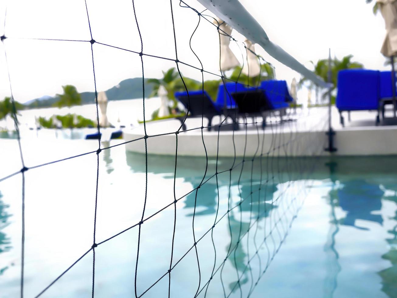 detalj av volleybollnät över blåvattenspool på en resort i phuket thailand foto