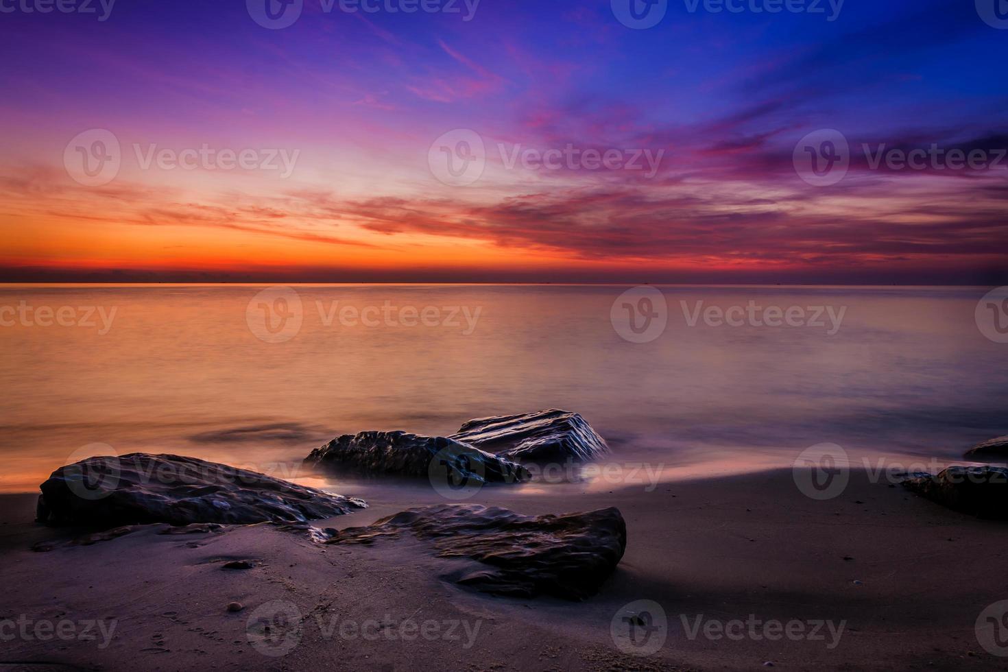 solnedgångshimmel med dramatiska solnedgångsmoln över havet. vacker soluppgång över havet foto