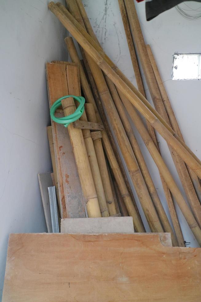 hög med begagnade brädor och bambu i hörnet av rummet foto