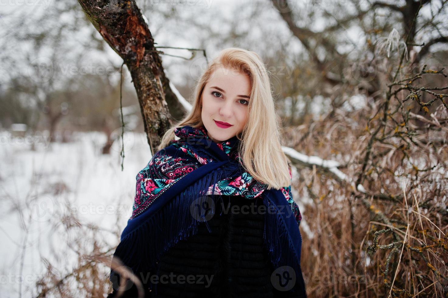 blond flicka med handbroderad halsduk poserade på vinterdagen. kvinnors näsduk. foto