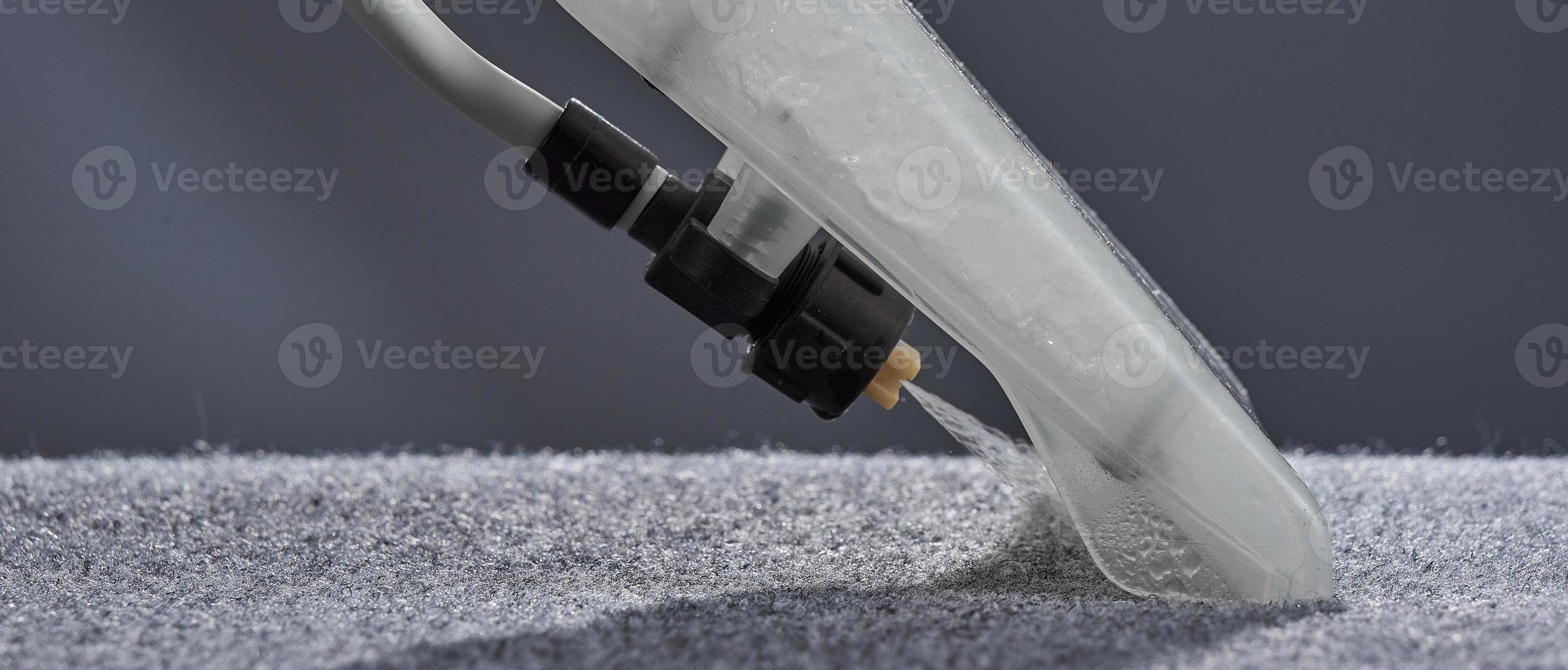 tvätta matta med dammsugare närbild på grå bakgrund. foto