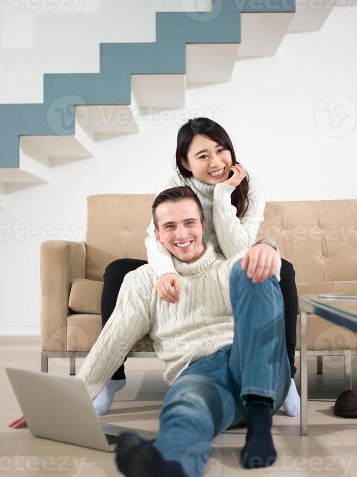 lyckligt multietniskt par som kopplar av hemma foto