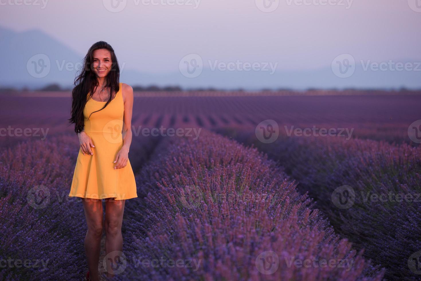 kvinna i gul klänning på lavendelfält foto