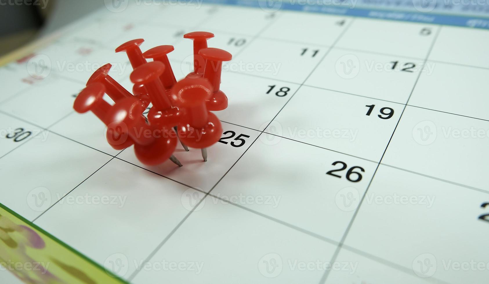 nummer 25 dag fästa på kalender med röd färg pin häftstift, koncept för hektisk dag foto