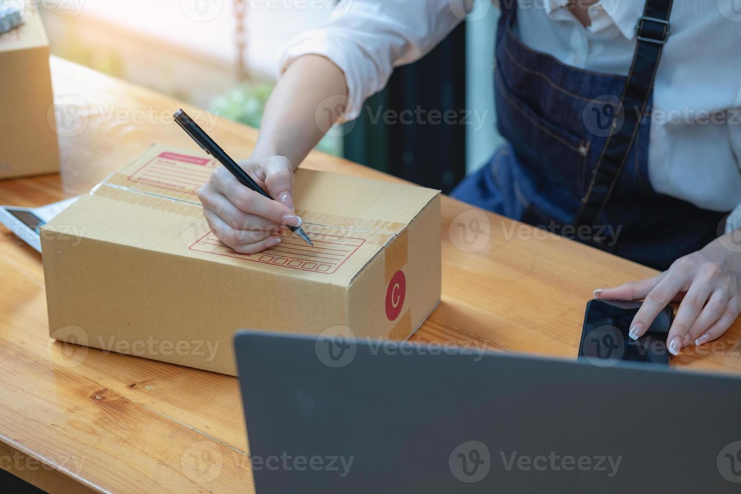 onlineförsäljning kvinna företagsägare ta emot beställningar och leverera produkter med lådor till kunder. online SM affärsidé. foto