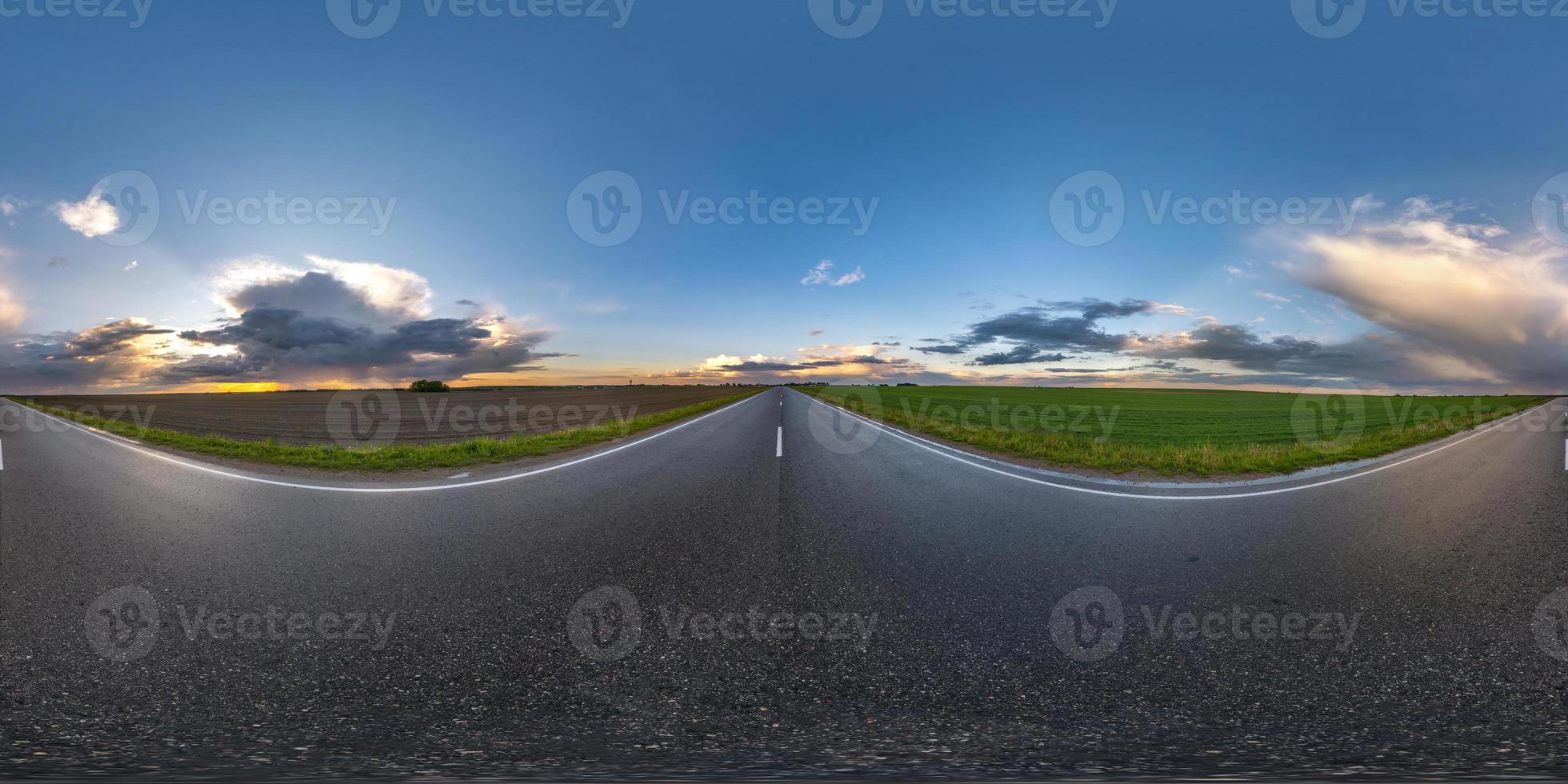 hel sfärisk hdri sömlös panorama 360 graders vinkelvy på våt trafikfri asfaltväg bland fält på kvällen efter storm med molnig himmel i ekvirektangulär projektion, vr ar innehåll foto