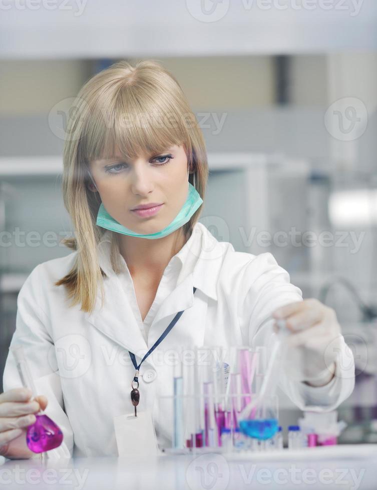 kvinnlig forskare som håller upp ett provrör i labbet foto