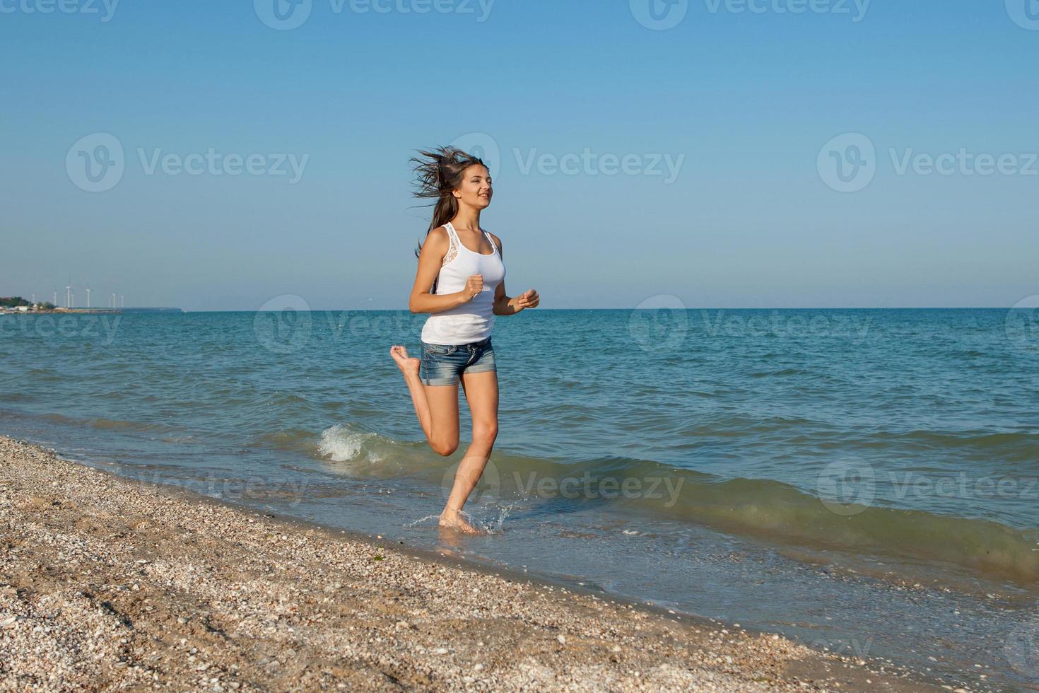 ung flicka springer på havet foto