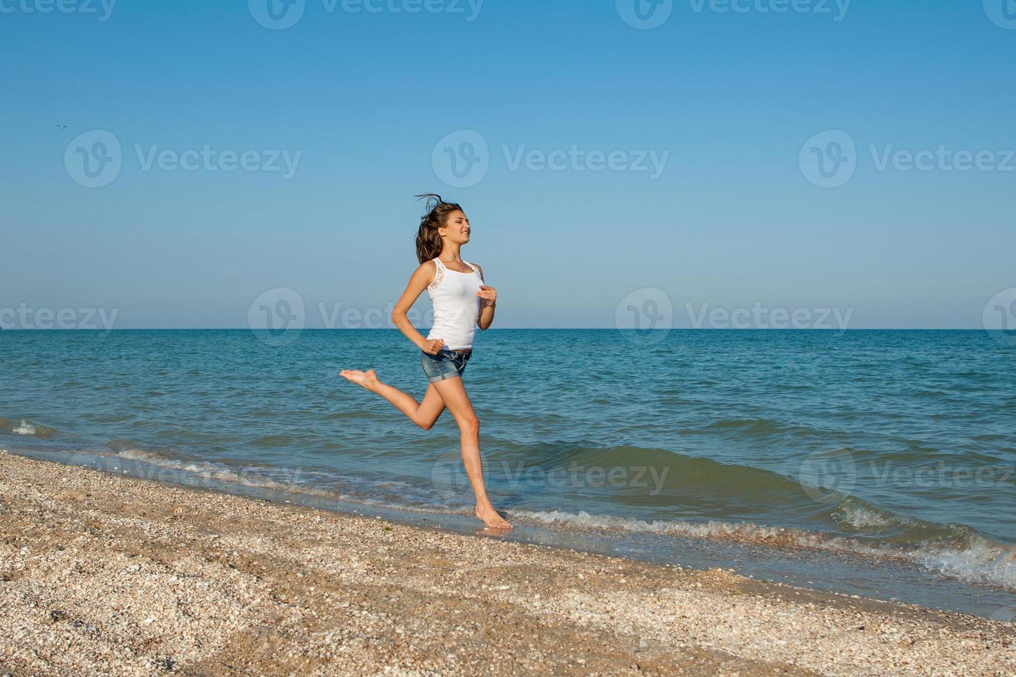 ung flicka springer på havet foto