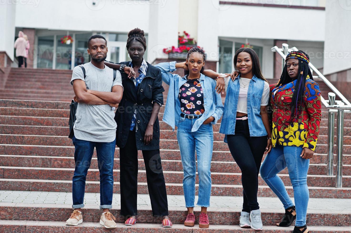 grupp på fem afrikanska högskolestudenter som spenderar tid tillsammans på campus på universitetsgården. svarta afro vänner studerar. utbildningstema. foto