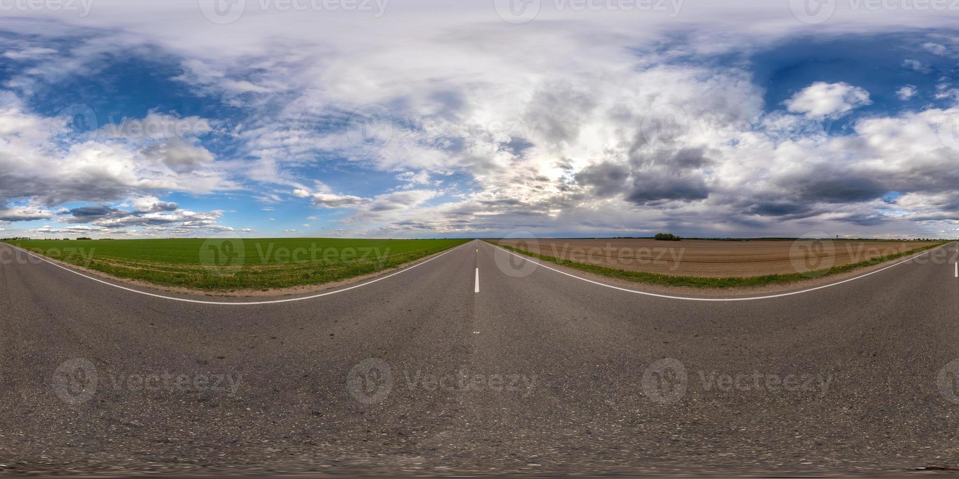 full sfärisk sömlös panorama 360 graders vinkelvy på trafikfri asfaltväg bland fält med molnig himmel i ekvirektangulär projektion, vr ar-innehåll foto