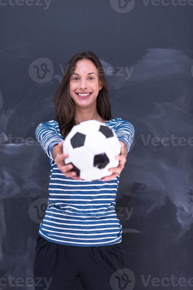kvinna som håller en fotboll framför krita ritbordet foto