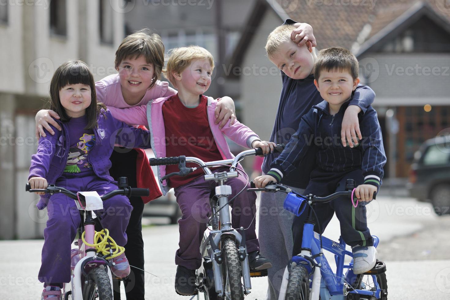 glad barngrupp som lär sig att köra cykel foto