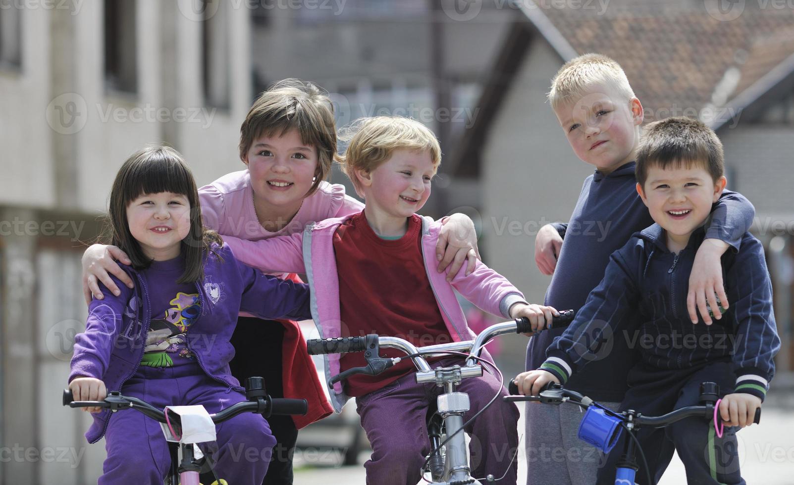 glad barngrupp som lär sig att köra cykel foto