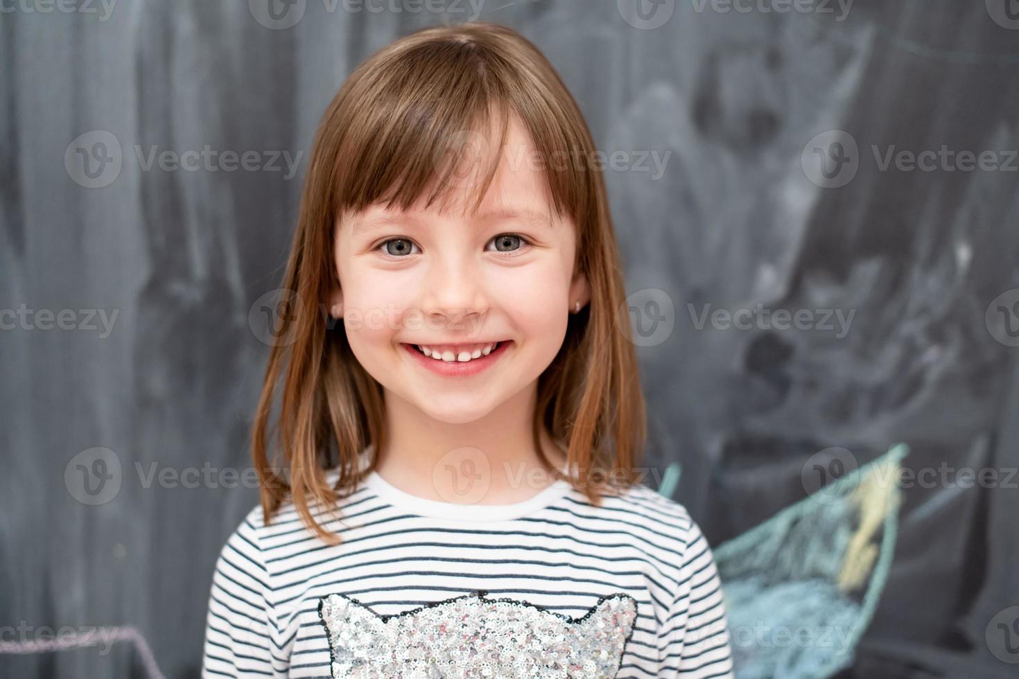 porträtt av liten flicka framför svarta tavlan foto