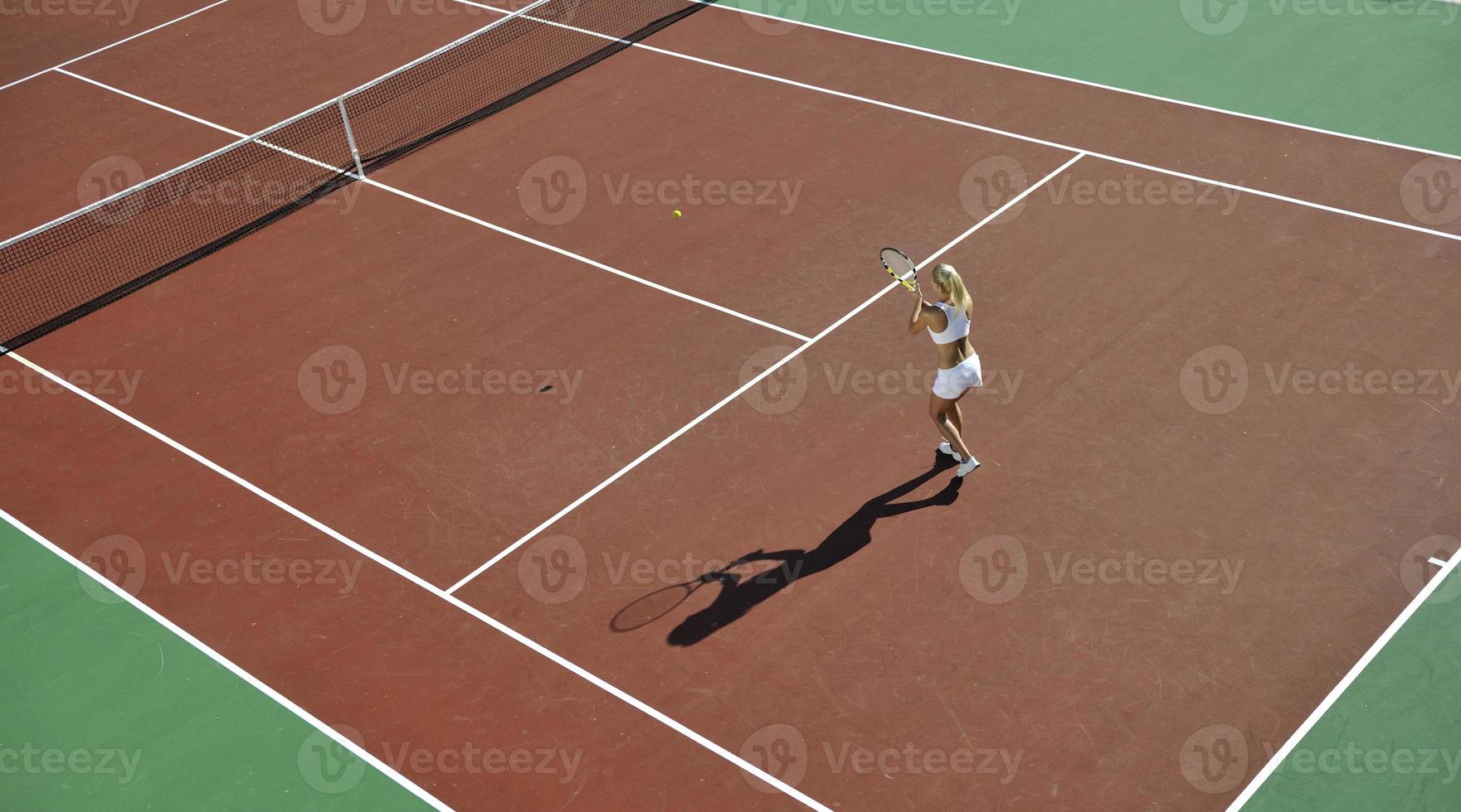 ung kvinna spela tennis utomhus foto