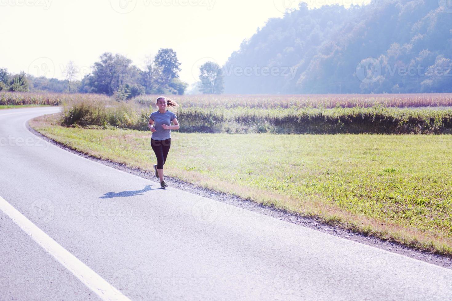 kvinna joggar längs en landsväg foto