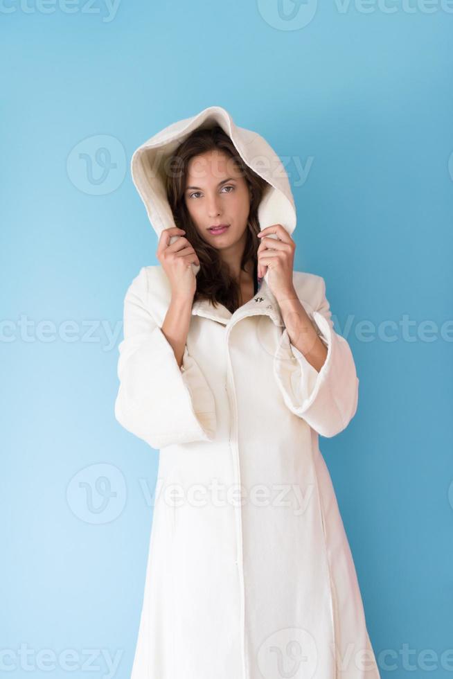 kvinna i en vit rock med huva isolerad på blå bakgrund foto