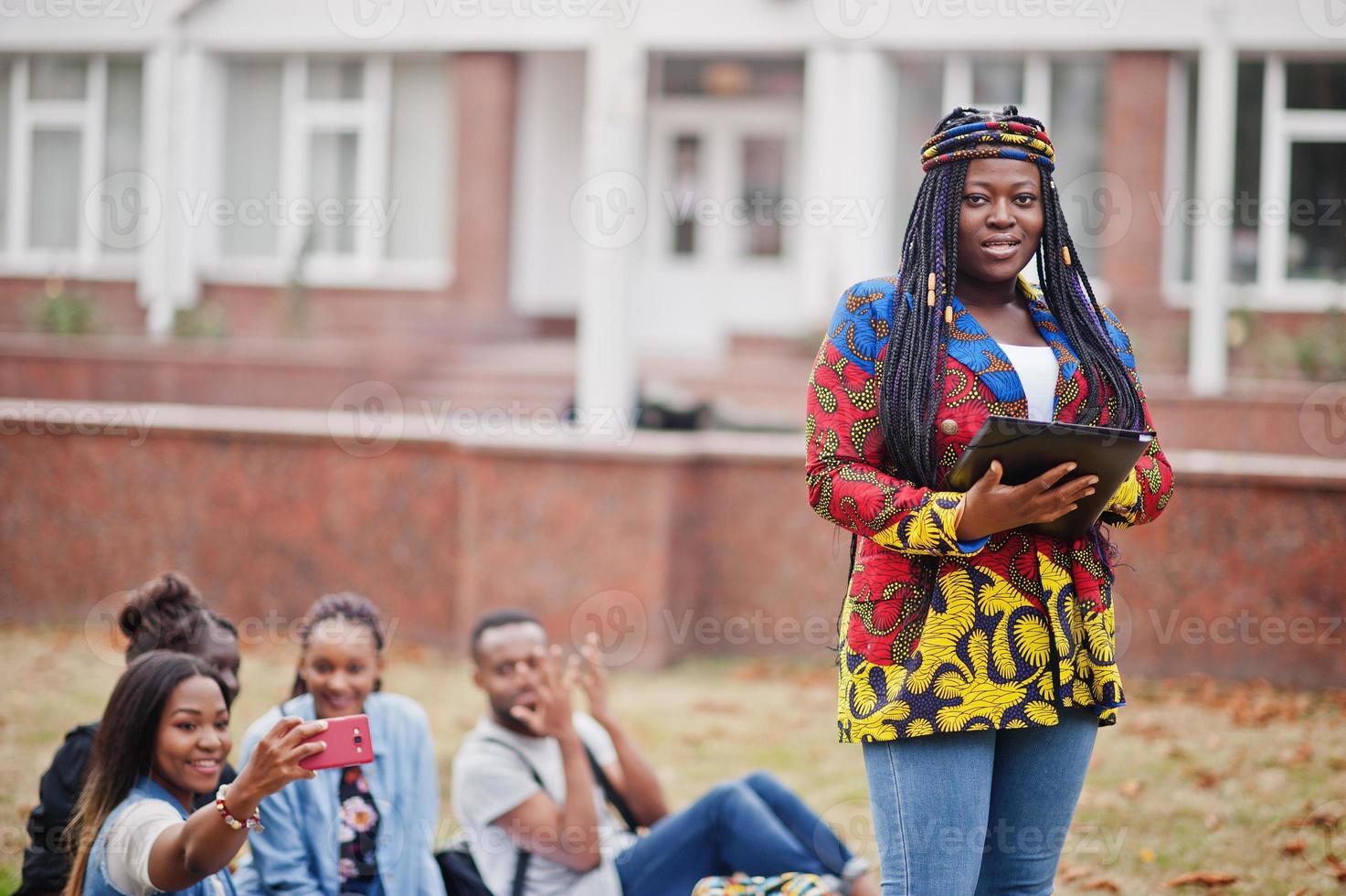 grupp på fem afrikanska högskolestudenter som spenderar tid tillsammans på campus på universitetsgården. svarta afro vänner studerar. utbildningstema. foto