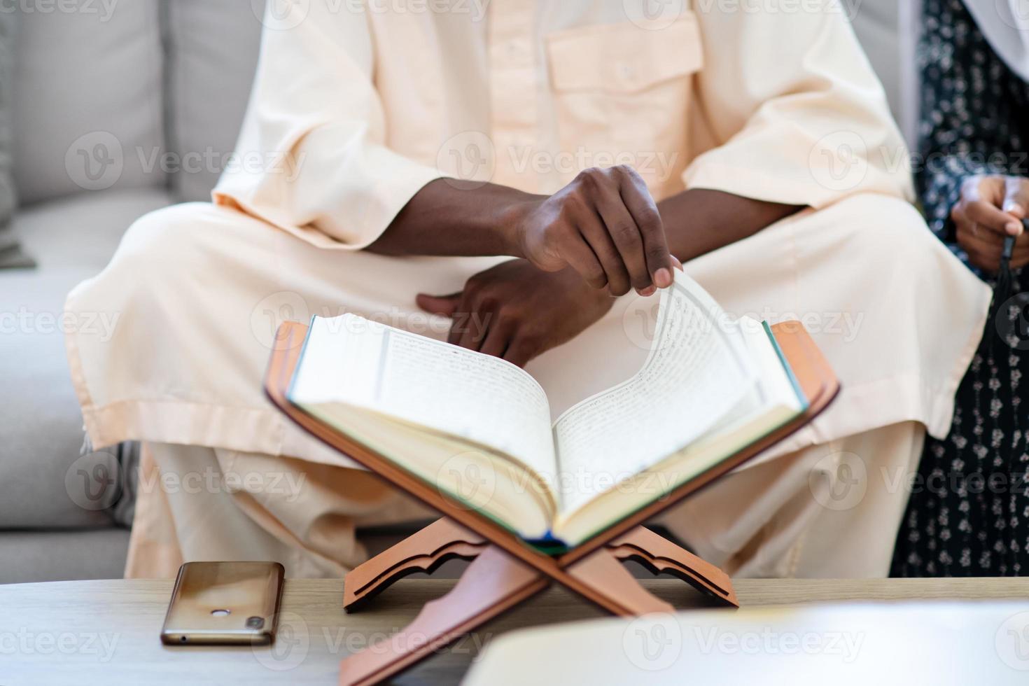 afrikanskt par hemma som läser Koranen foto