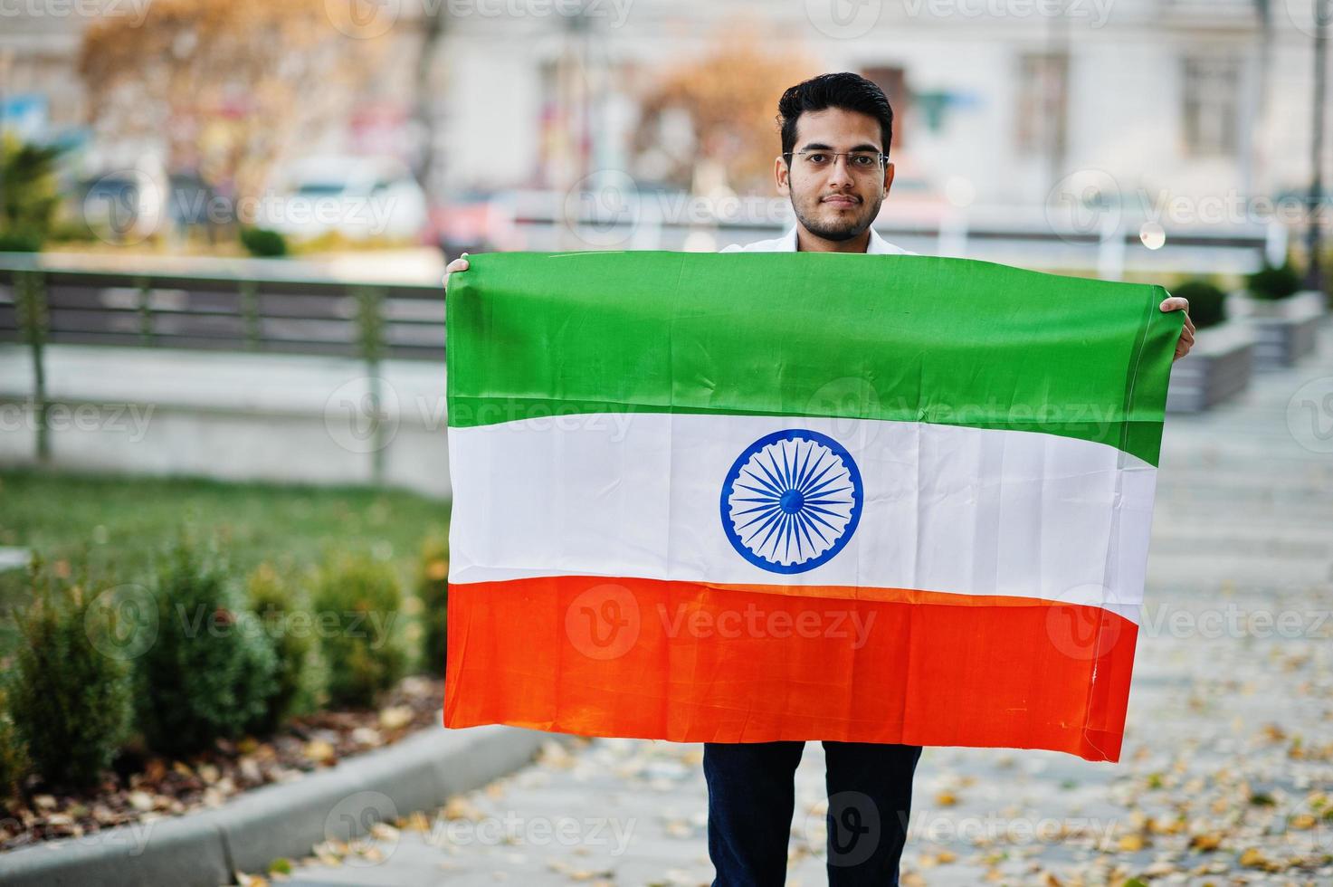 sydasiatisk indisk manlig student med Indien flagga poserade utomhus. foto