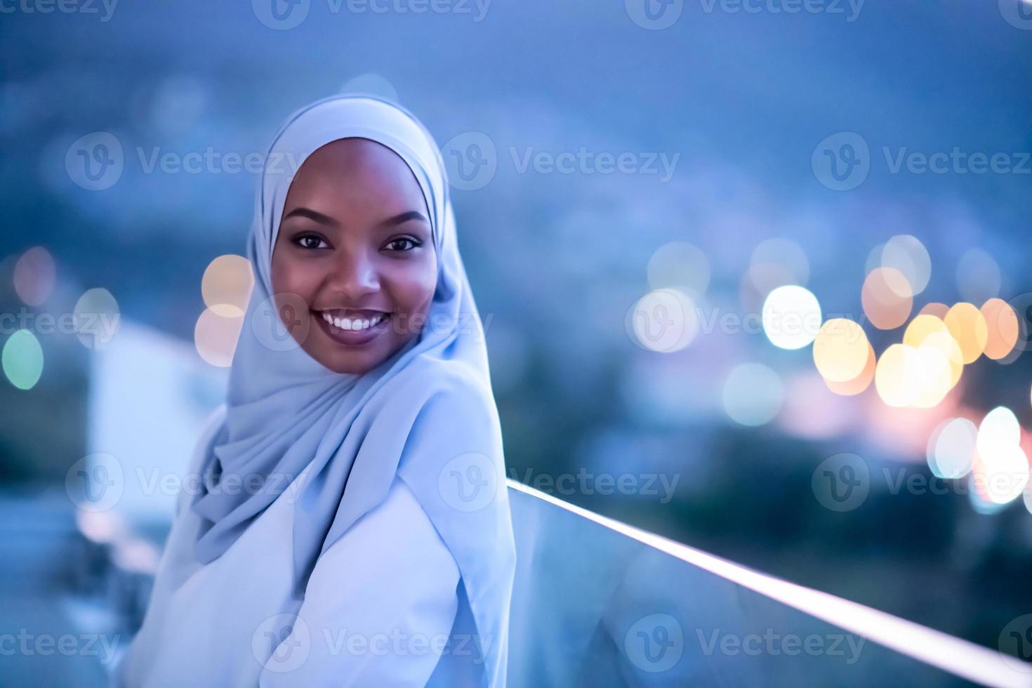 afrikansk modern muslimsk kvinna i natten på balkongen foto