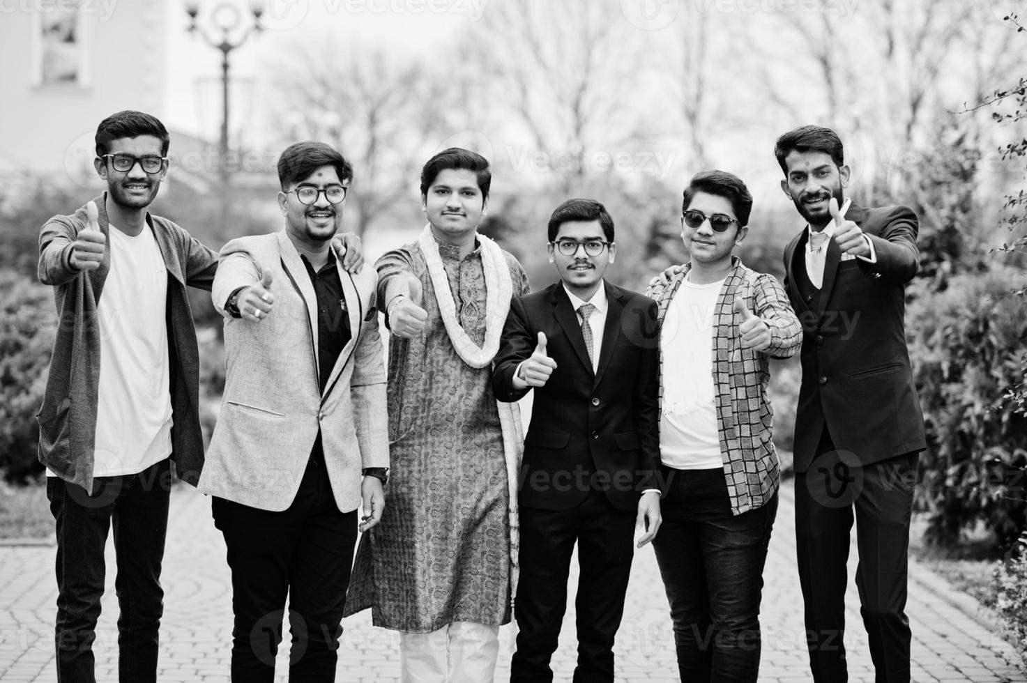 grupp om sex sydasiatiska indiska män i traditionella, vardags- och affärskläder stående och visar tummen upp. foto